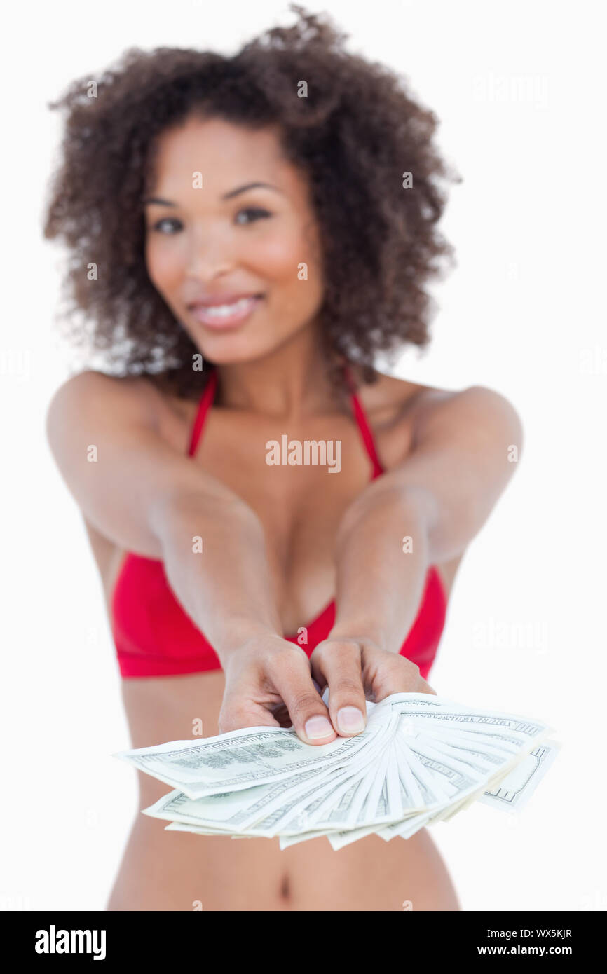Fan of notes being held by a young woman against a white background Stock Photo