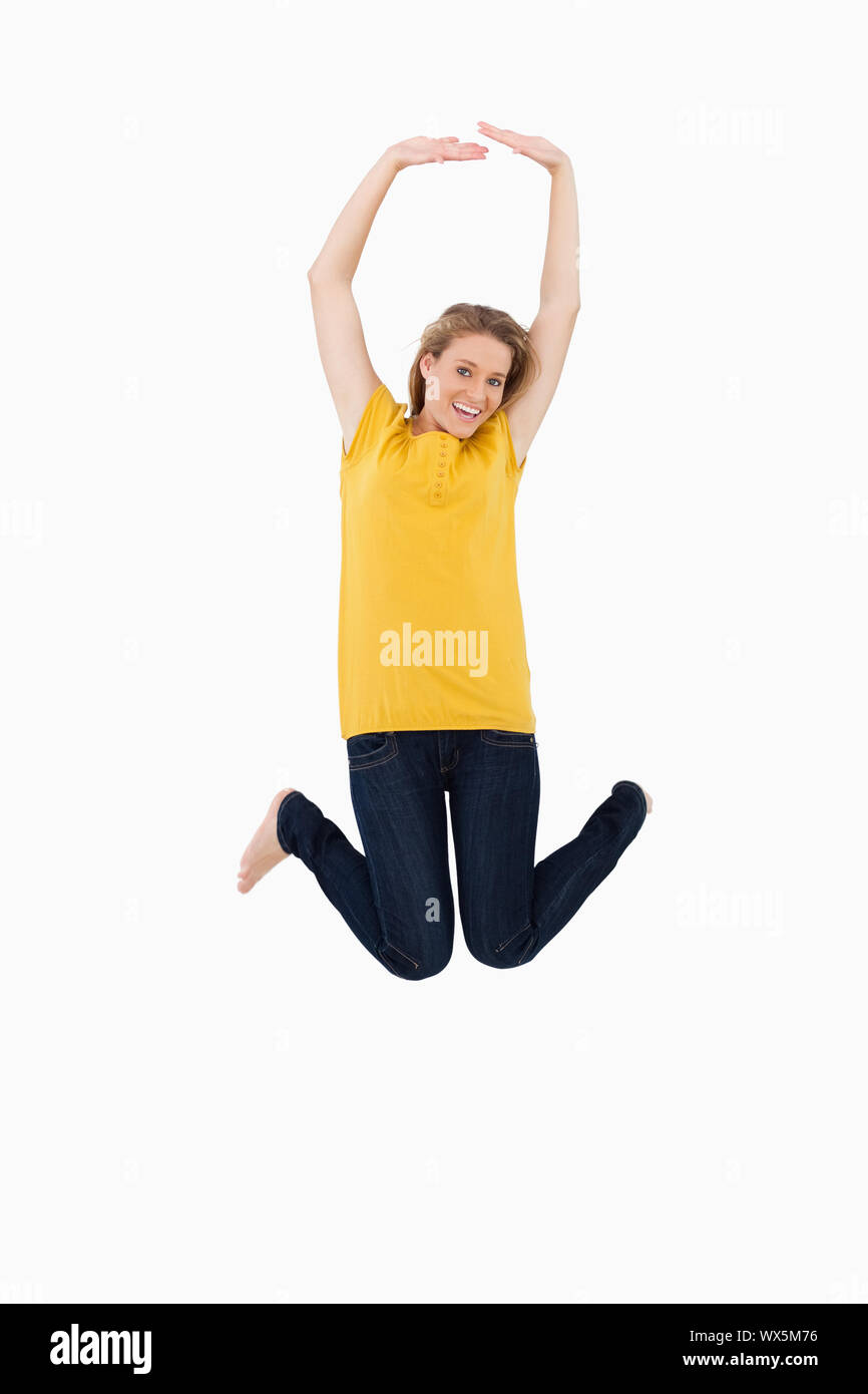 Young woman jumping against white background Stock Photo - Alamy