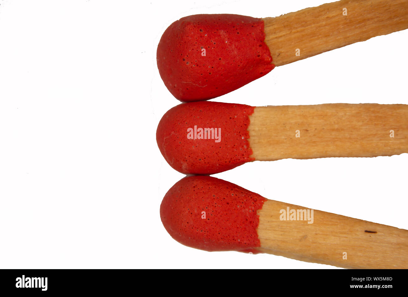 Matchstick with red head under the magnifying glass Stock Photo