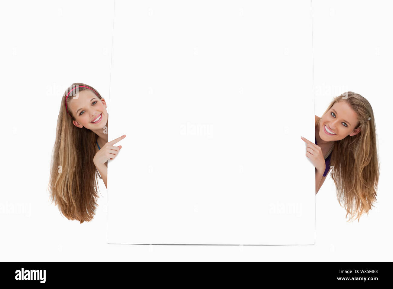 Portrait of two long hair women back of a blank sign against white ...