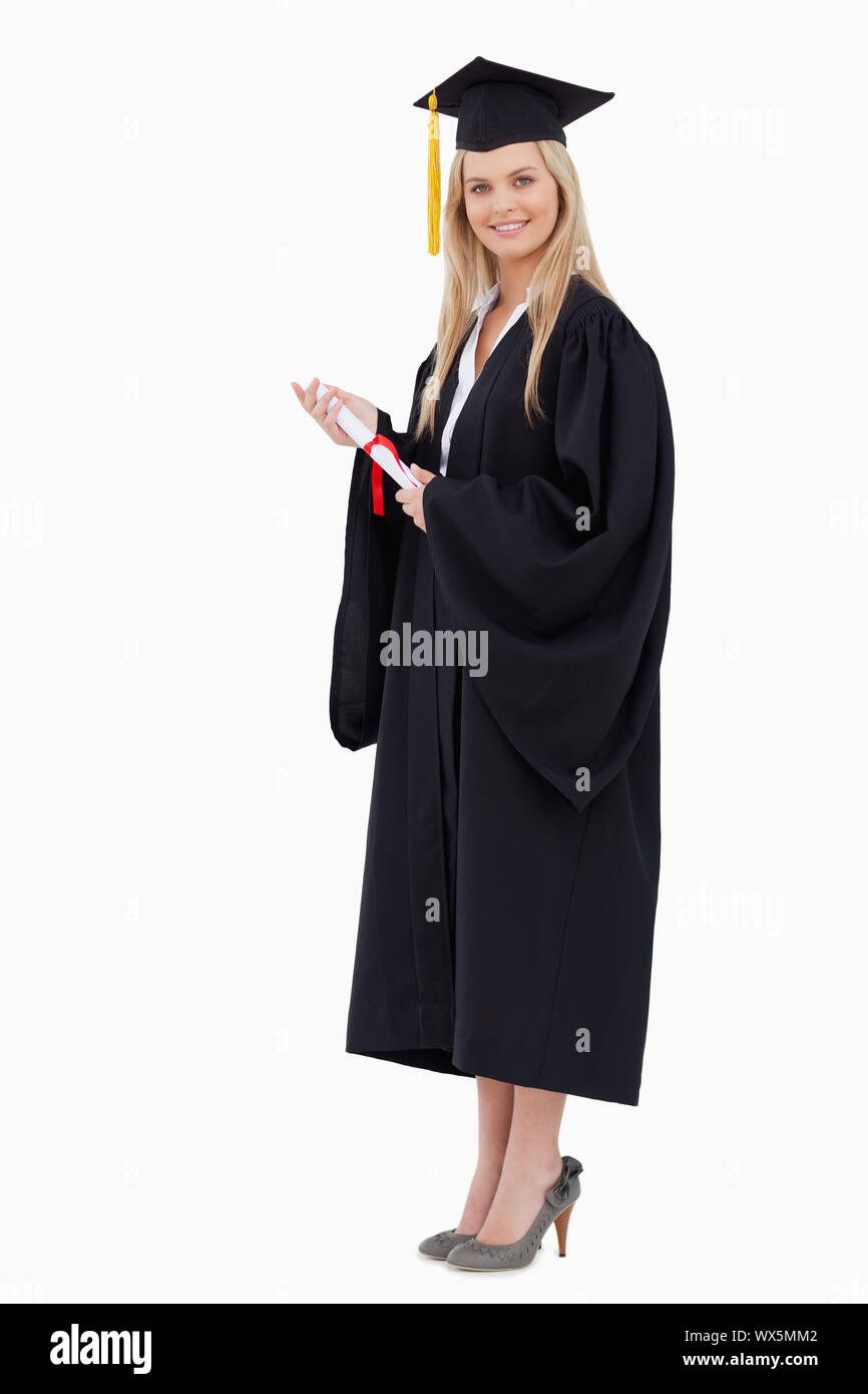 Blonde student in graduate robe holding a diploma against white ...