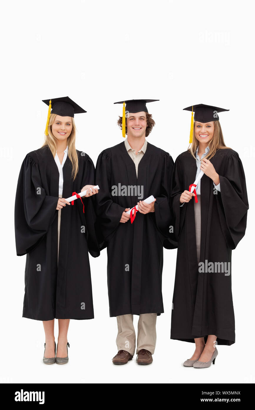 Three students in graduate robe holding a diploma against white ...