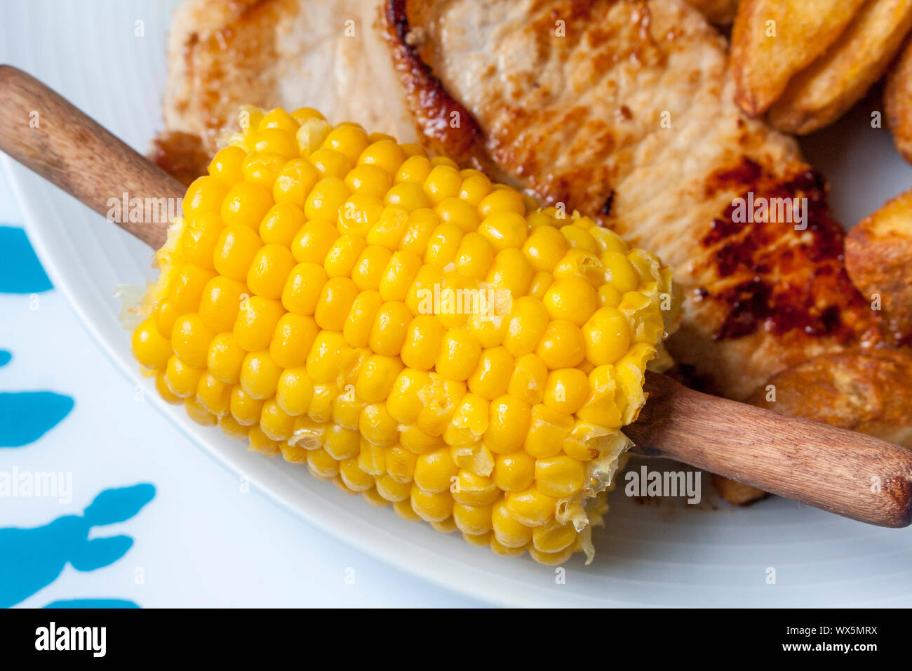 Freshly cooked corn on the cob on the side of a plate Stock Photo