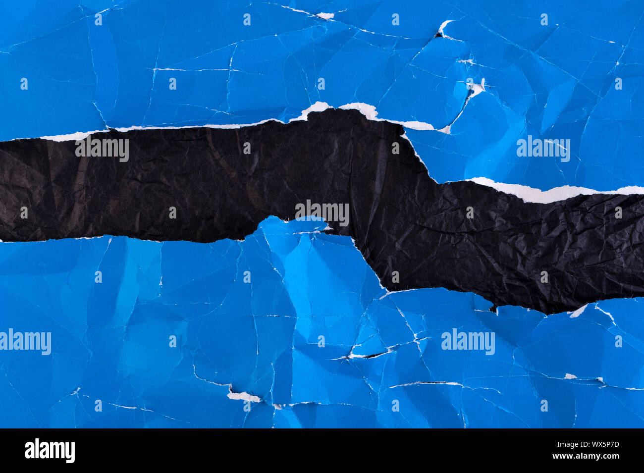 Multi-colored crumpled real vivid paper sheets texture background. Blue, black. Stock Photo