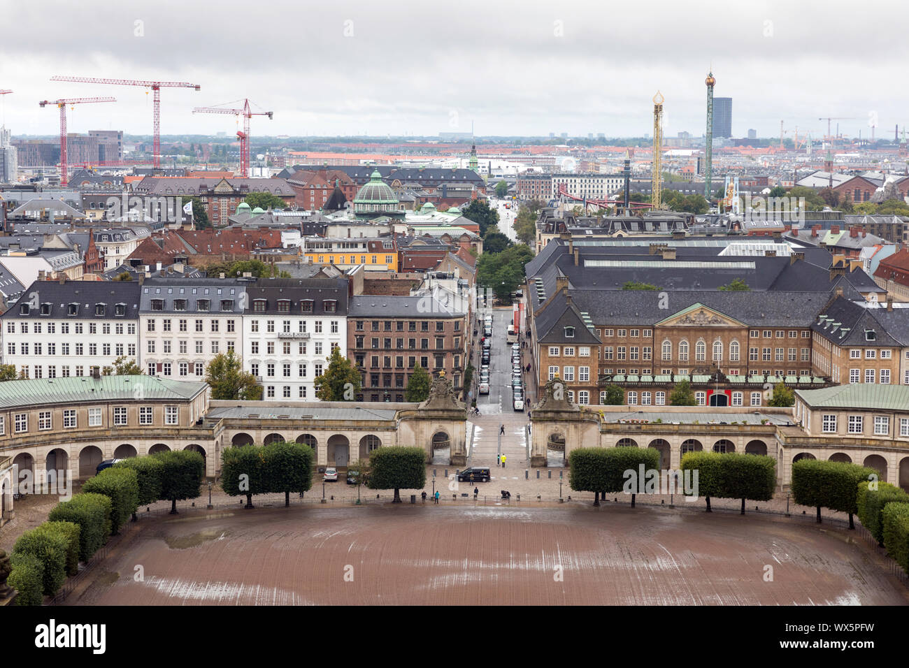The skyline of Copenhagen, Denmark, with the stable yard of the Christiansborg Palace in the foreground and the fairground rides of Tivoli Gardens (r) Stock Photo