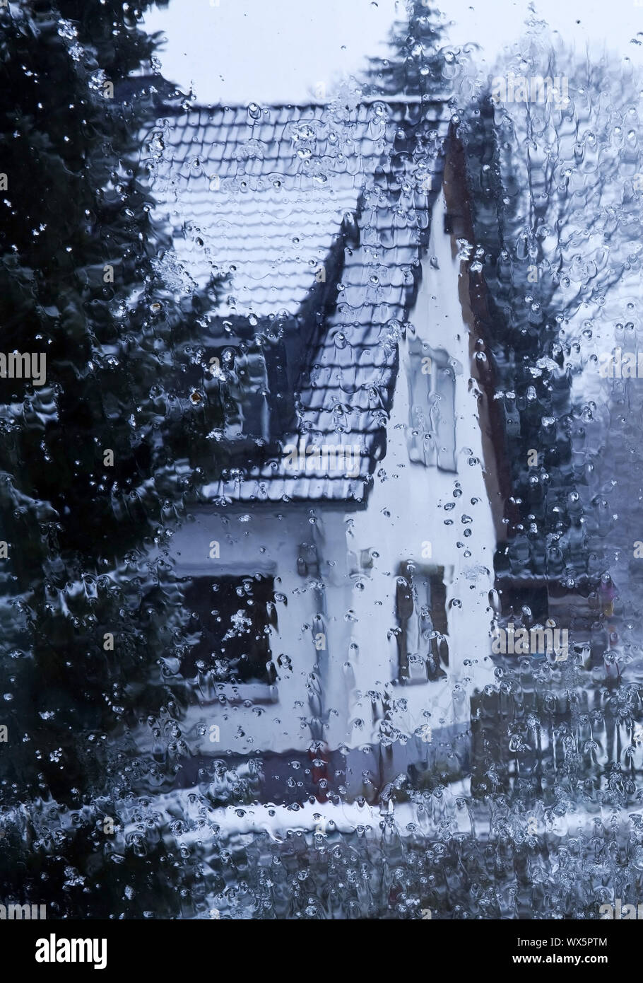 Regen auf einer Fesnsterscheibe mit Blick auf ein Haus im Winter, Witten, Nordrhein-Westfalen, Deuts Stock Photo