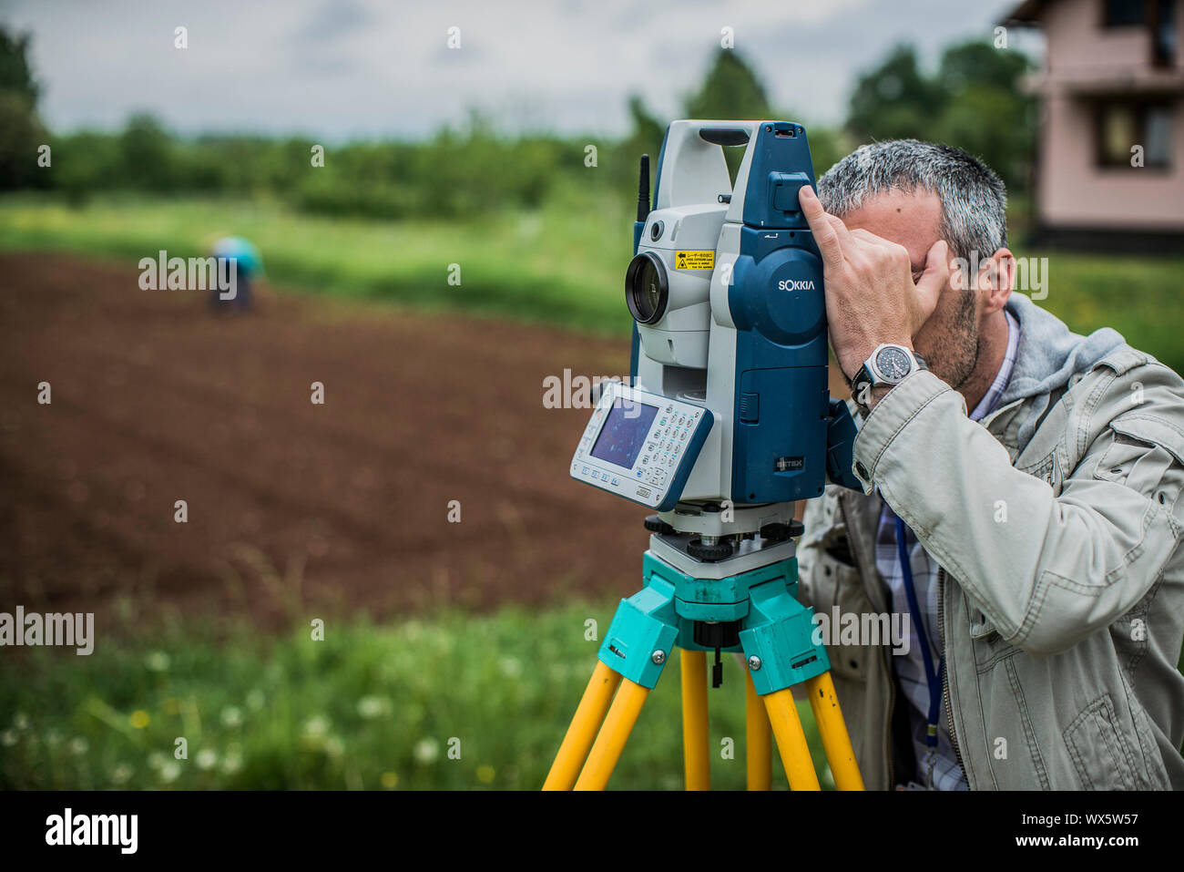 Surveying technician measures the area of land in Bosnia and