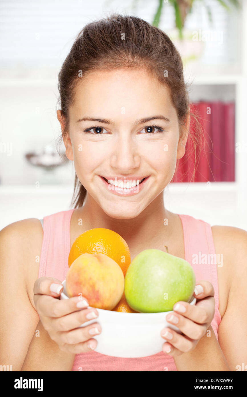 Portrait of young happy smiling woman with bowl of fruits Stock Photo ...