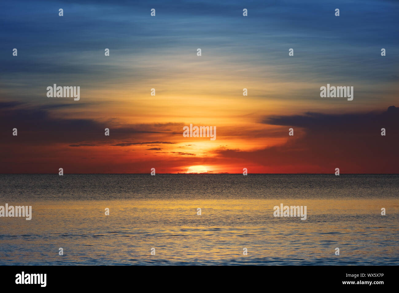 sunset over the ocean on clear evening Stock Photo