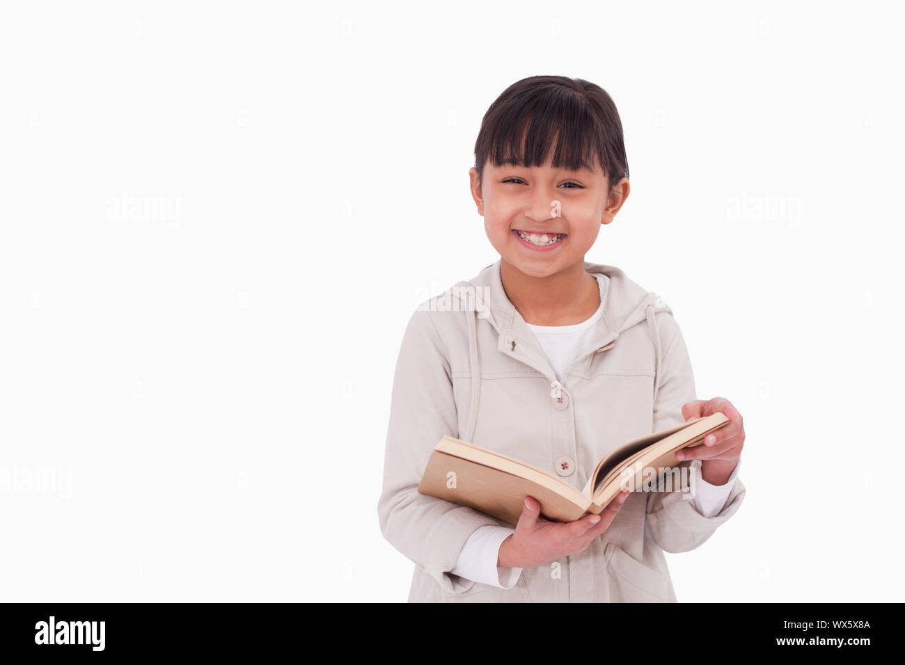 Smiling girl reading a book against a white background Stock Photo - Alamy