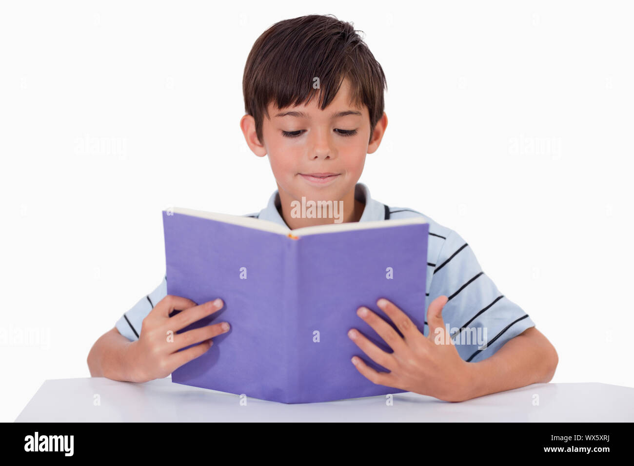 Focused boy reading a book against a white background Stock Photo