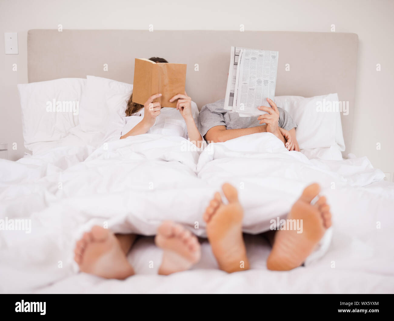 Playful couple reading in their bedroom Stock Photo