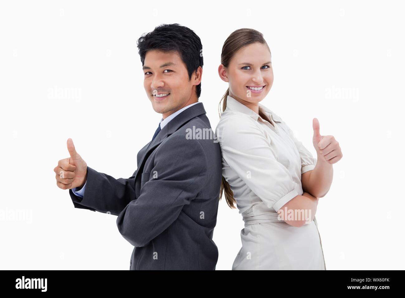 Business people standing back to back with the thumb up against a white ...