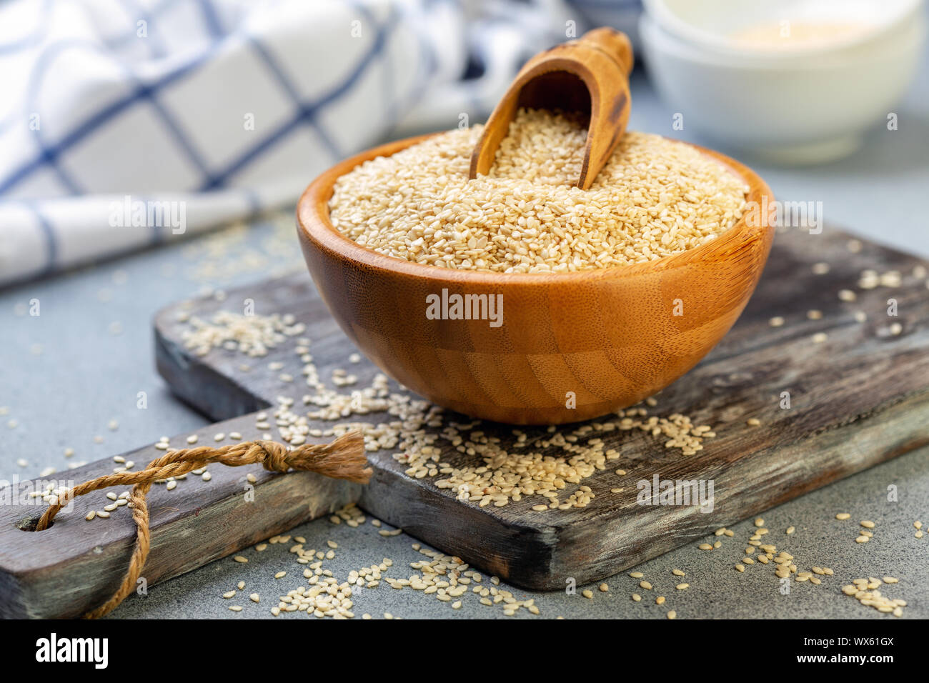 Bowl with sesame seeds and wooden scoop. Stock Photo