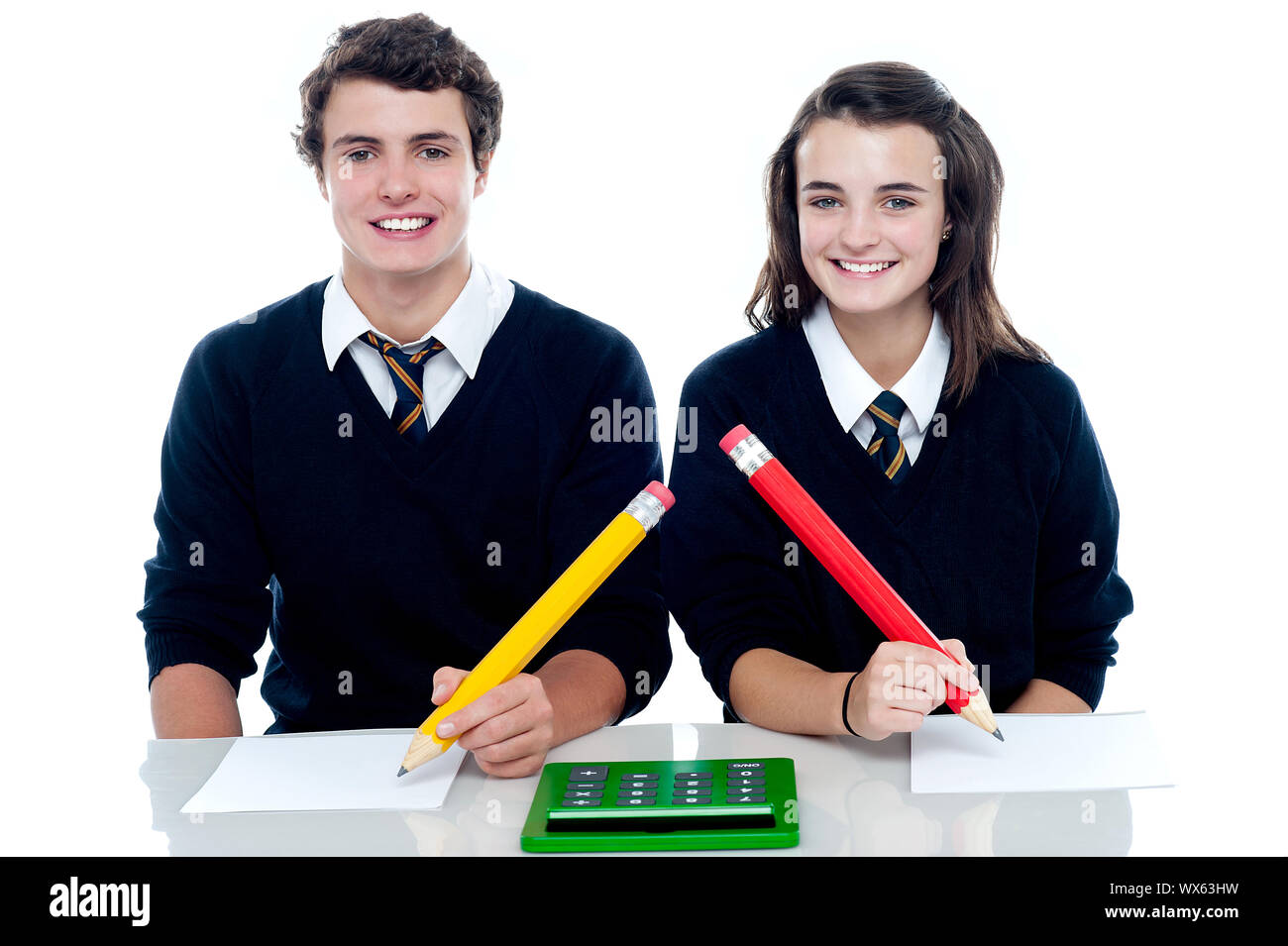Studious students ready to take down the notes. Holding big pencil with calculator lying on desk Stock Photo