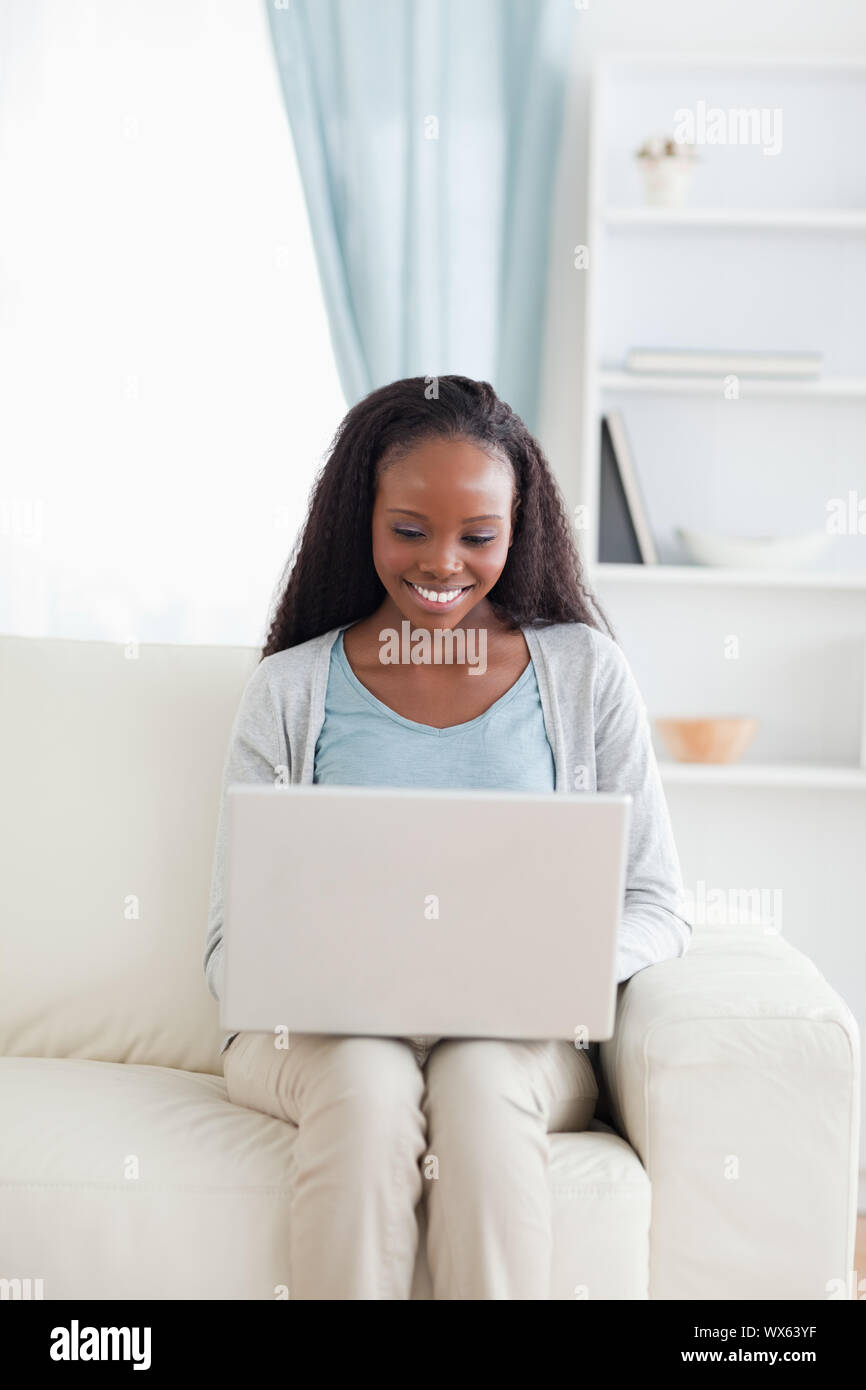 Smiling woman on sofa working on her laptop Stock Photo - Alamy