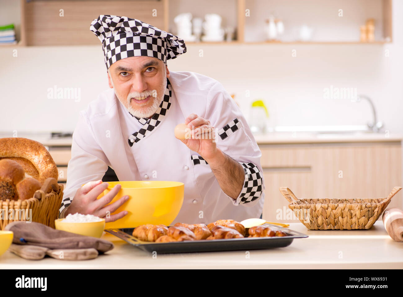 Old male baker working in the kitchen Stock Photo - Alamy