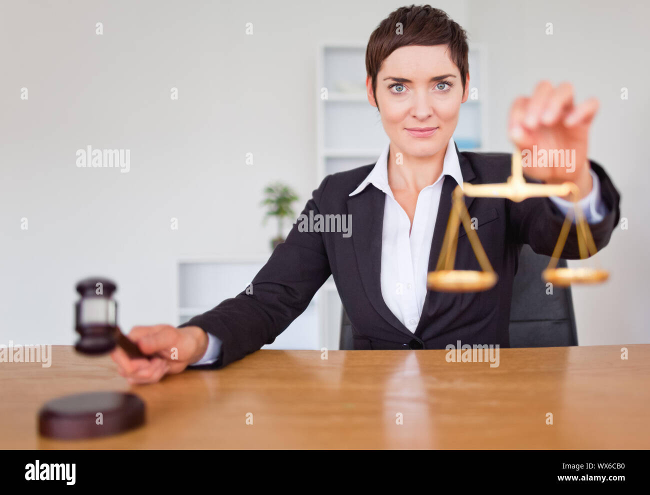 Serious woman with a gavel and the justice scale in her office Stock Photo Alamy Serious woman with a gavel and the justice scale in her office Stock Photo Alamy