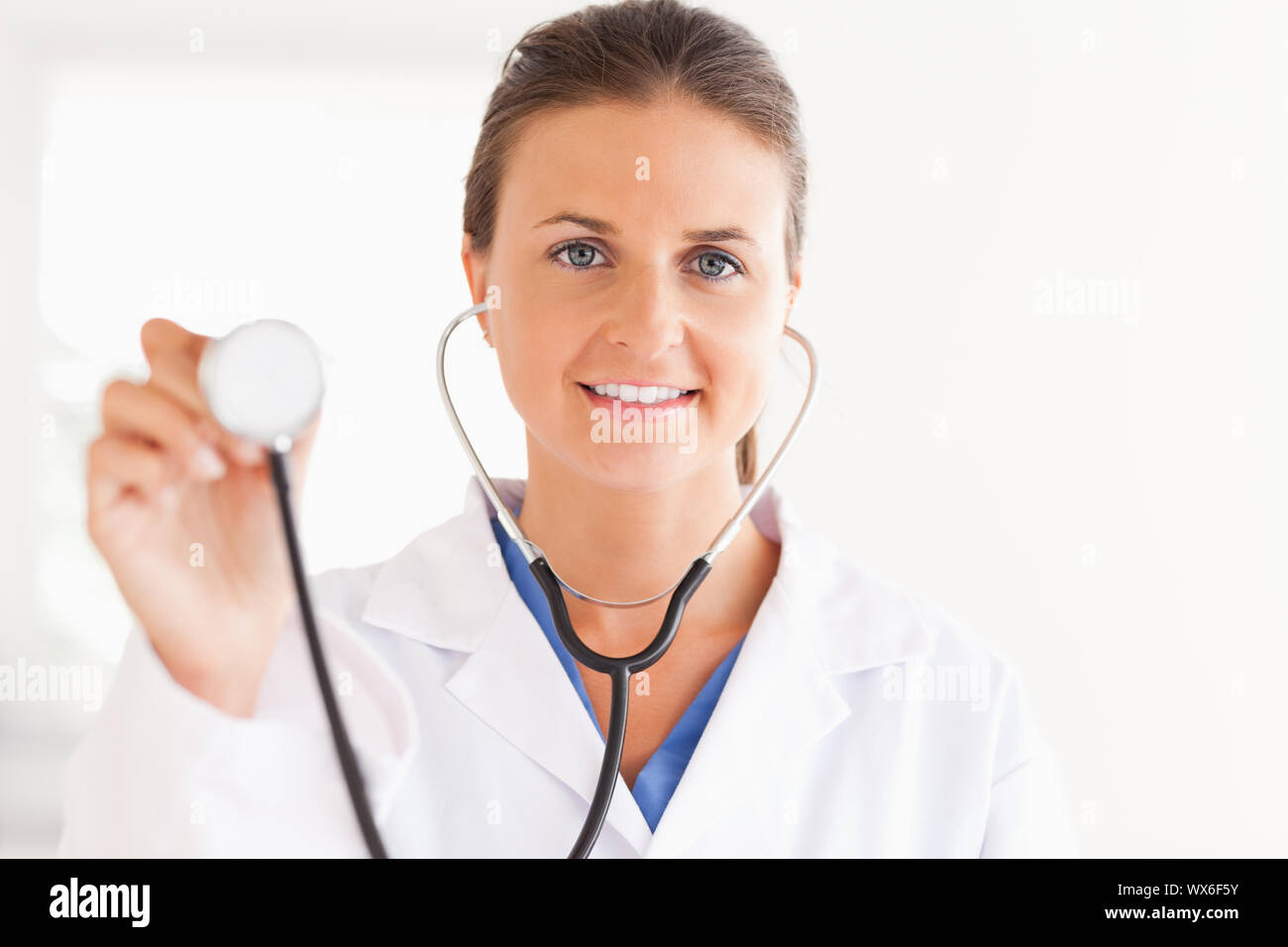 Gorgeous Brunette Doctor Showing Stethoscope Looking Into The Camera In 