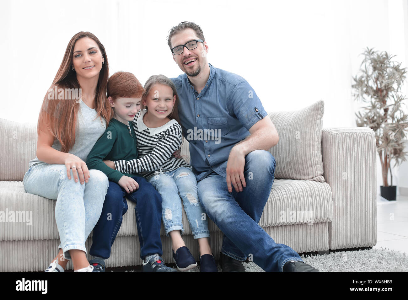 happy family sitting on the couch in the living room Stock Photo - Alamy