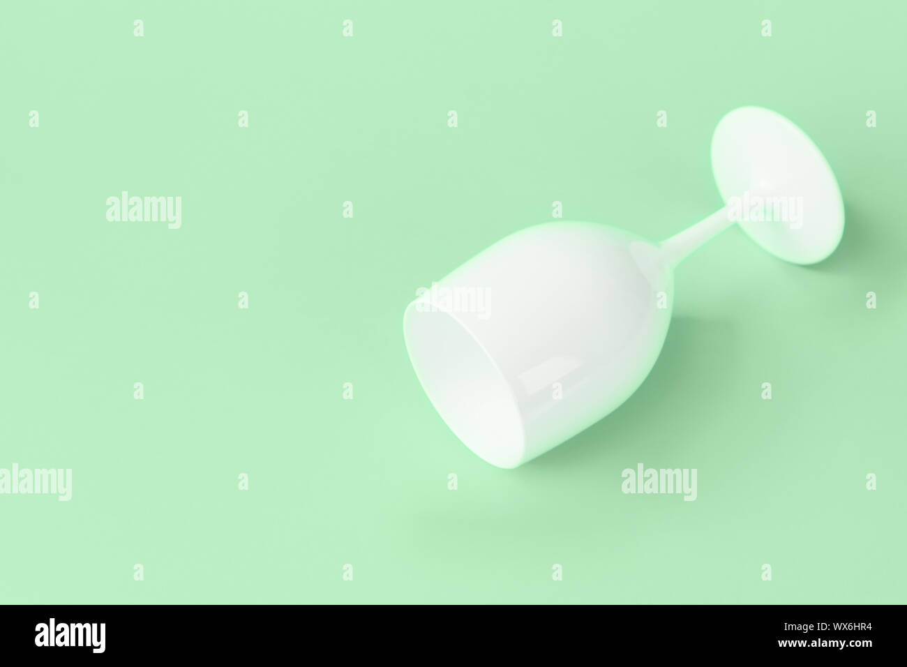 Creative festive white glass on a green mint background. Minimalistic Flat lay Stock Photo