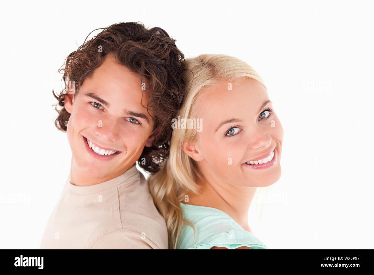 Happy couple smiling into the camera in a studio Stock Photo - Alamy