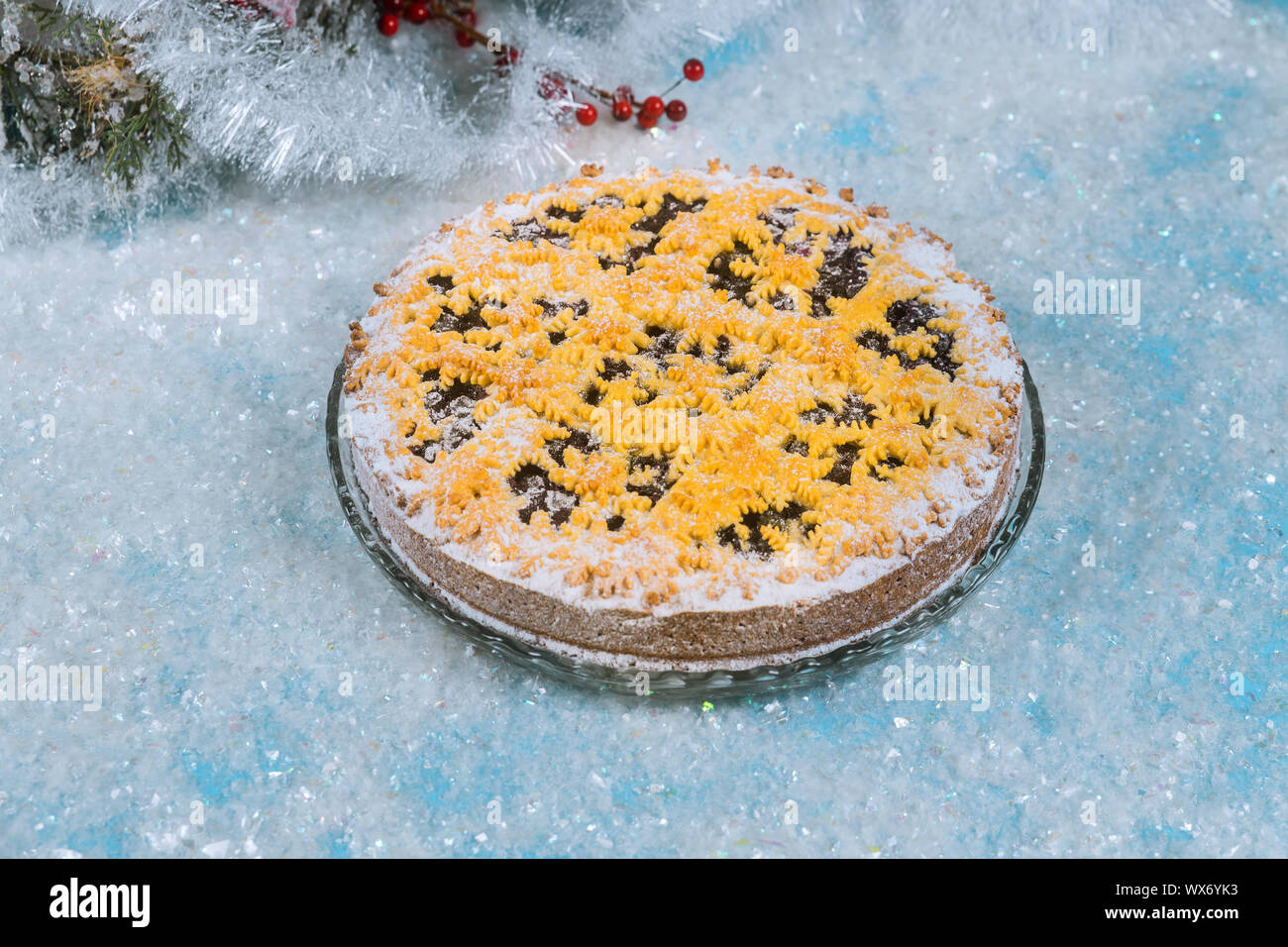 Berry pie with christmas decoration on artificial sparkle snow. Stock Photo