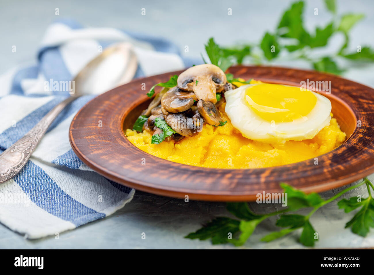Polenta with caramelized mushrooms, egg and parsley Stock Photo Alamy