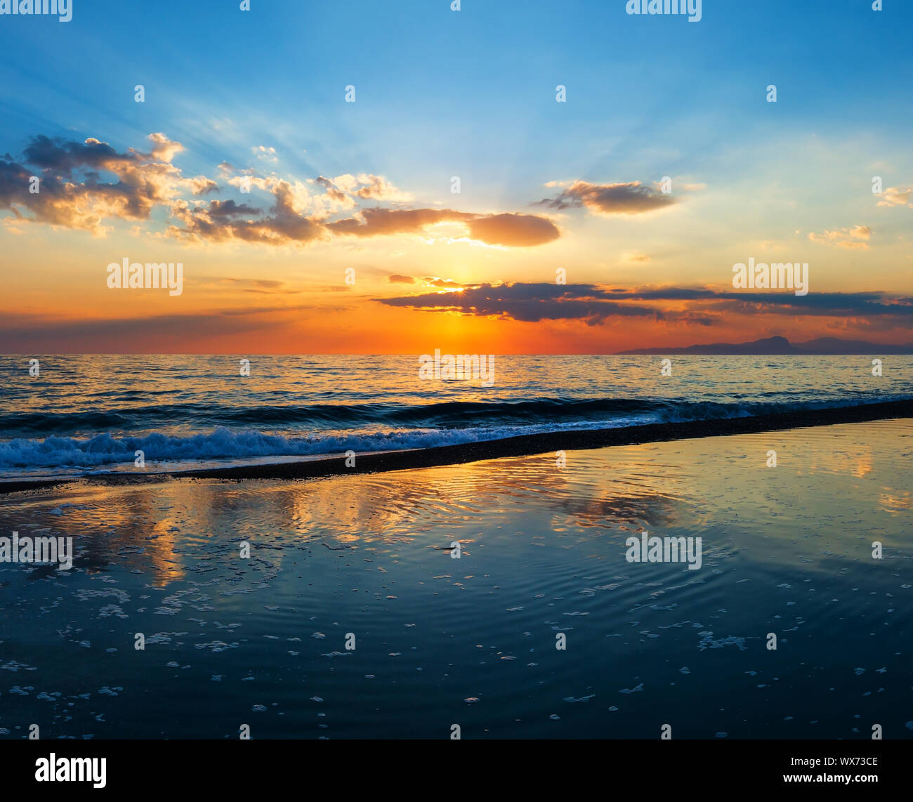 Sunset on sea beach Stock Photo - Alamy