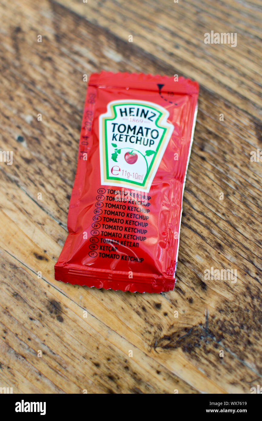Heinz tomato ketchup sachet on a wooden table Stock Photo
