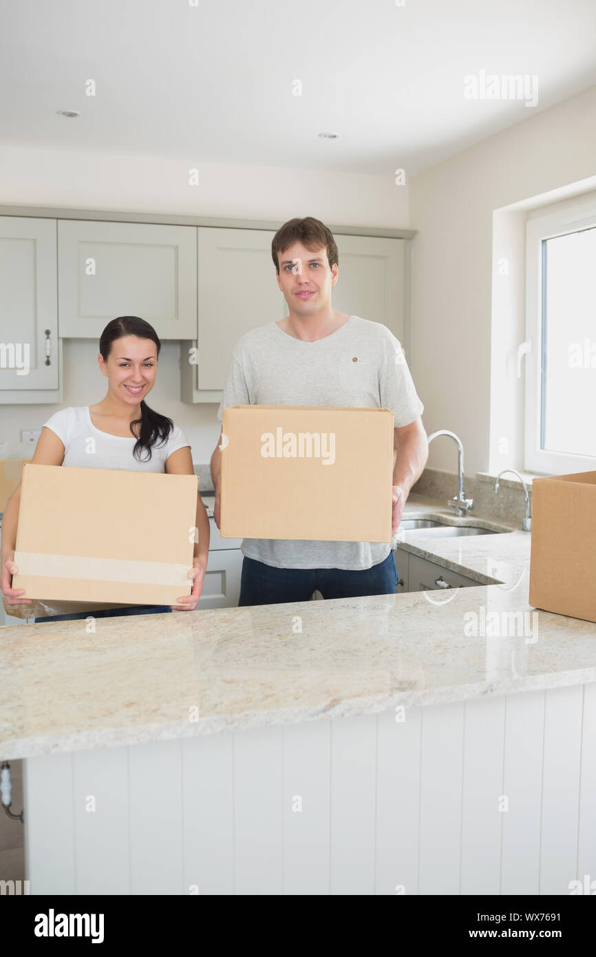 Young couple holding boxes for a relocation in their hands Stock Photo