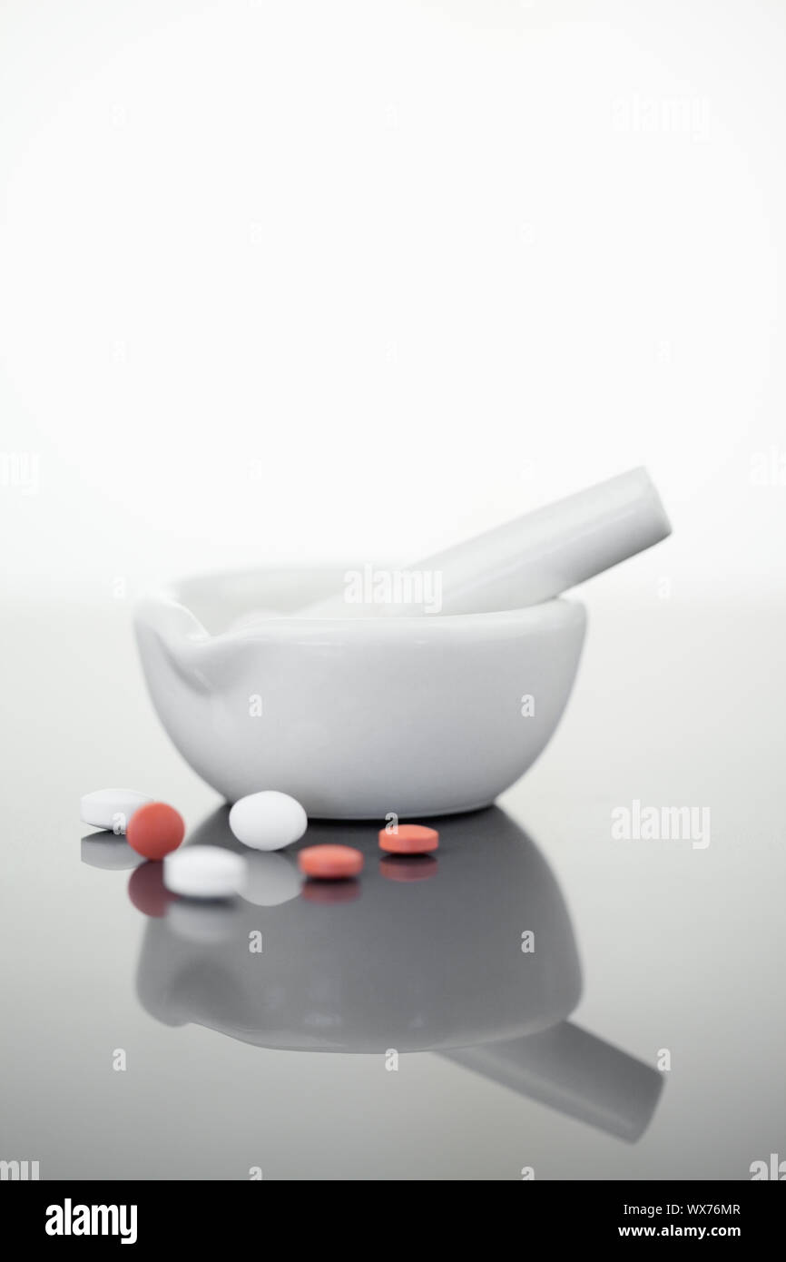 Mortar and pestle with pills against a white background Stock Photo Alamy