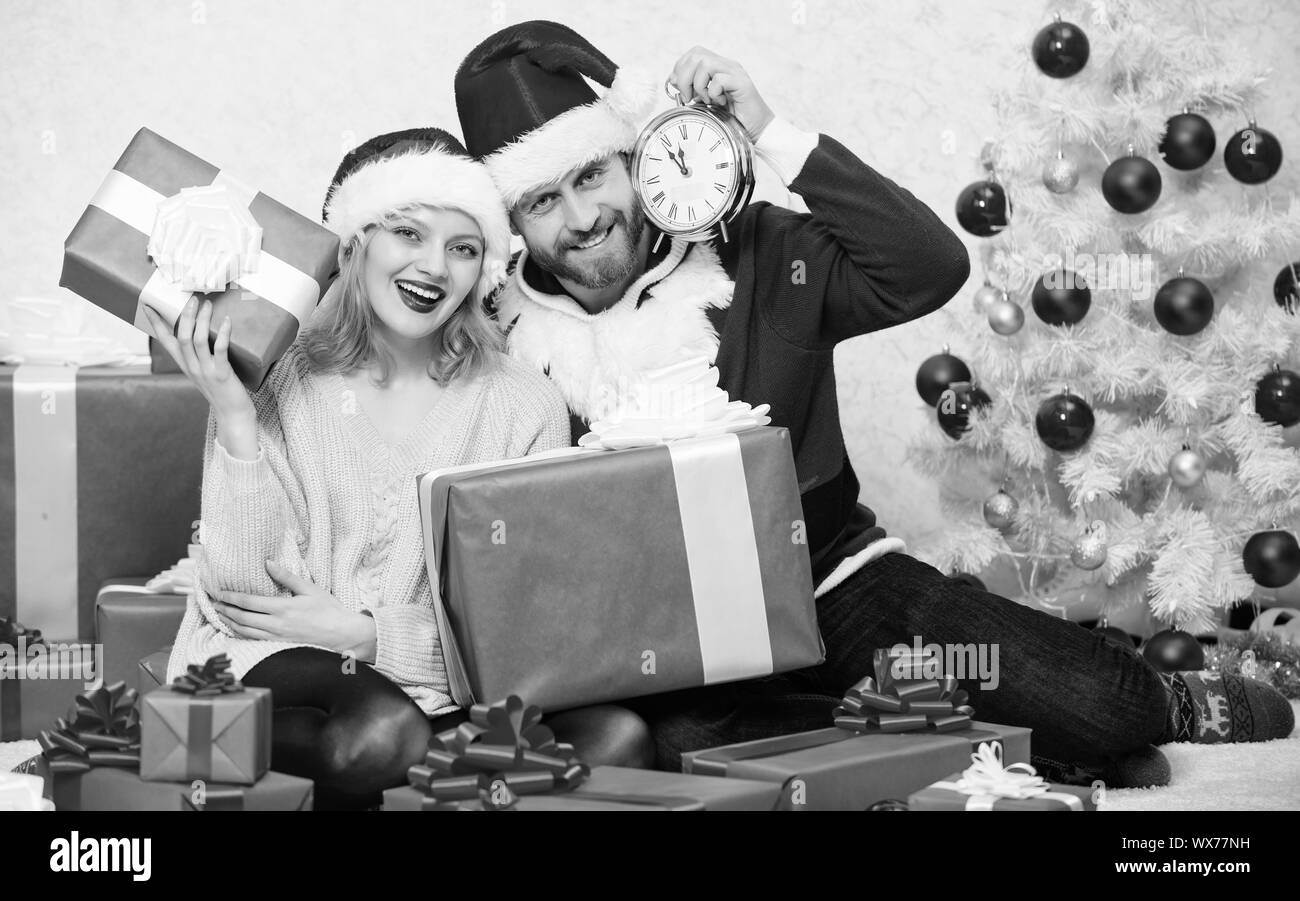Christmas fun concept. Couple wear hats as santa claus christmas tree background. Couple in love enjoy christmas celebration. It is easy to spread happiness around. Happy family celebrate christmas. Stock Photo