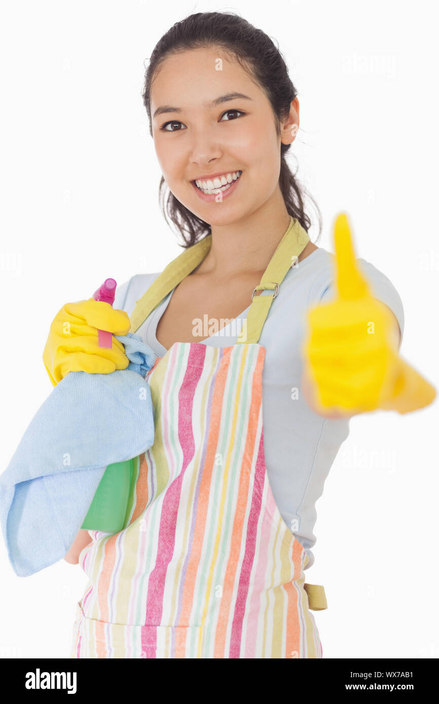 Smiling woman in apron holding cleaning products giving thumbs up Stock ...