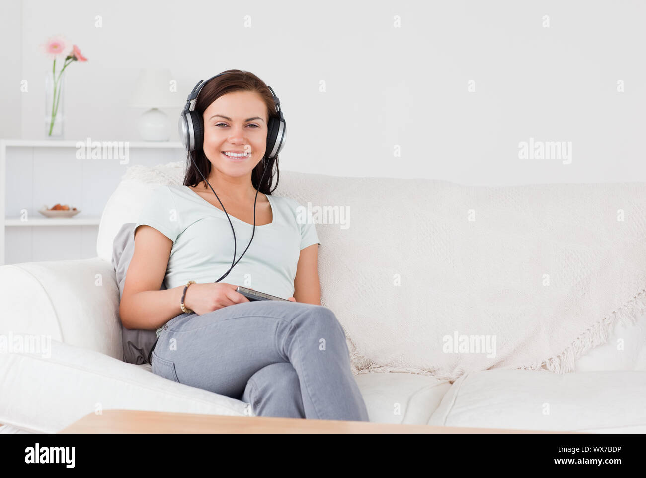 Charming woman listening to music in her living room Stock Photo - Alamy