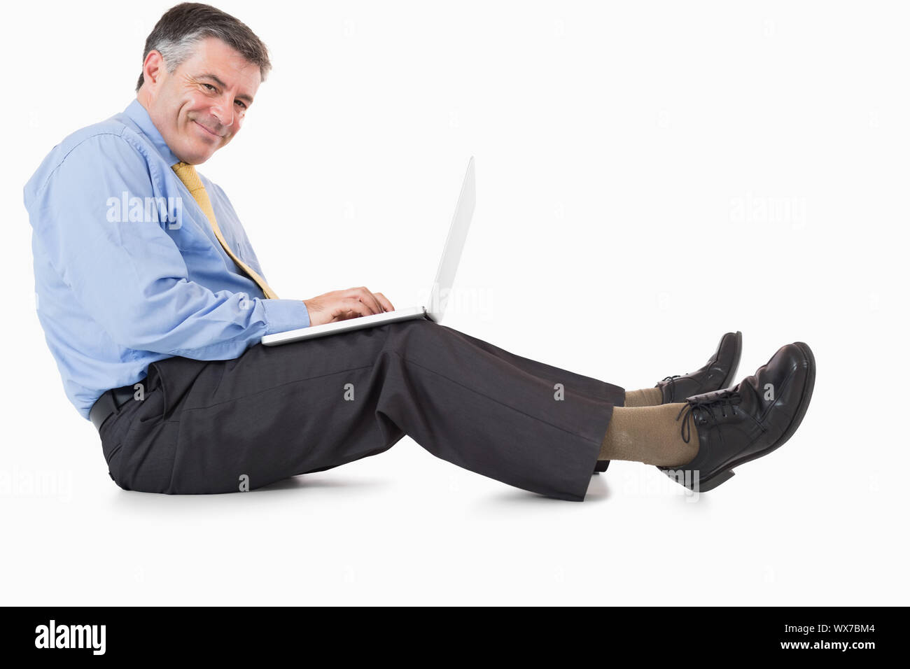 Happy businessman working with laptop on the floor Stock Photo - Alamy