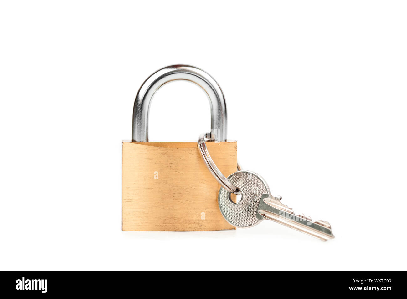 Padlock standing with  key hanging against white background Stock Photo