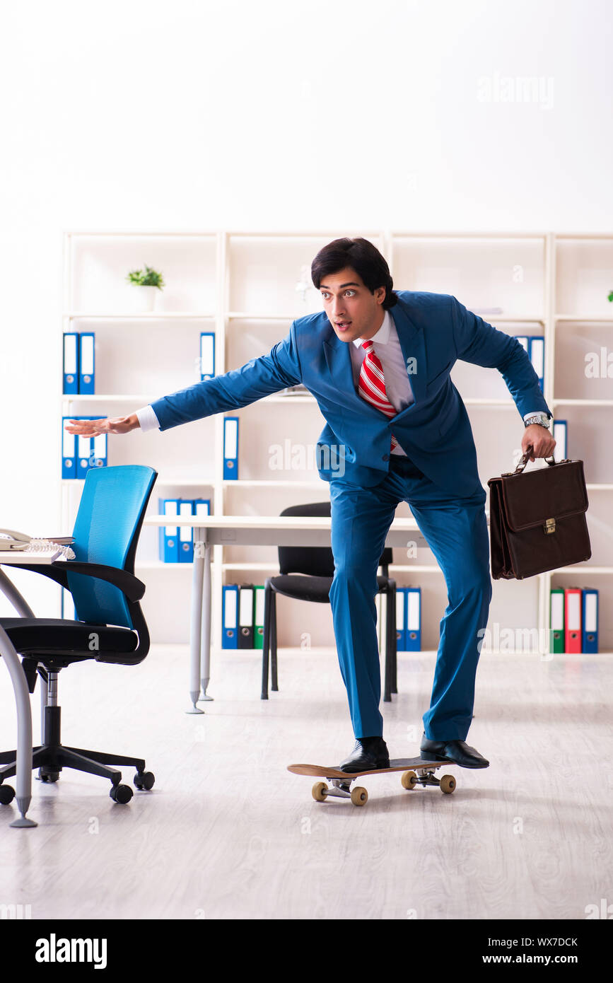 Young handsome businessman with longboard in the office Stock Photo - Alamy