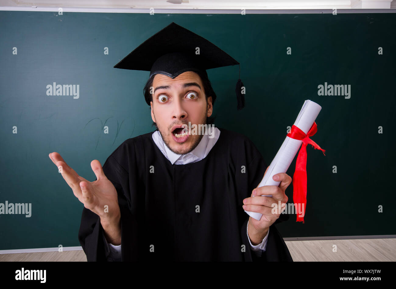 Graduate Front Use Graduate student in front of green board Stock Photo - Alamy