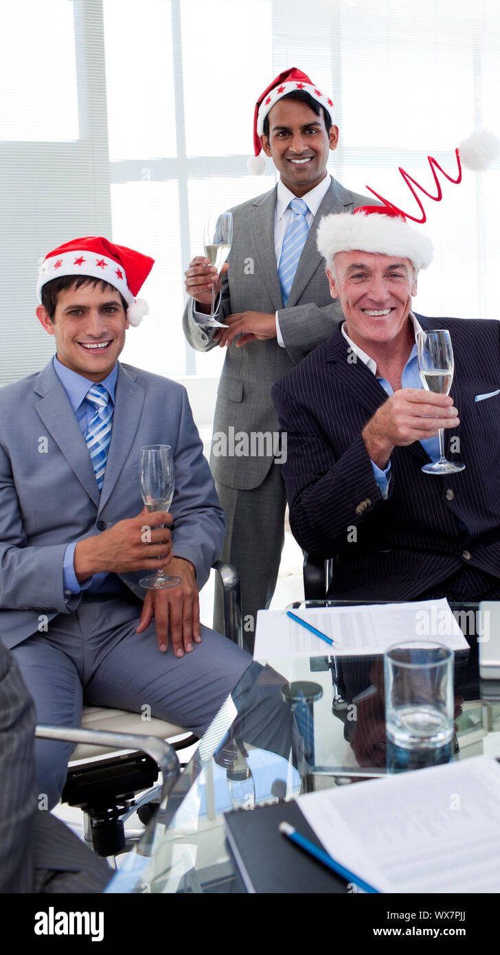 Confident businessmen wearing novelty Christmas hat at a party in the office Stock Photo