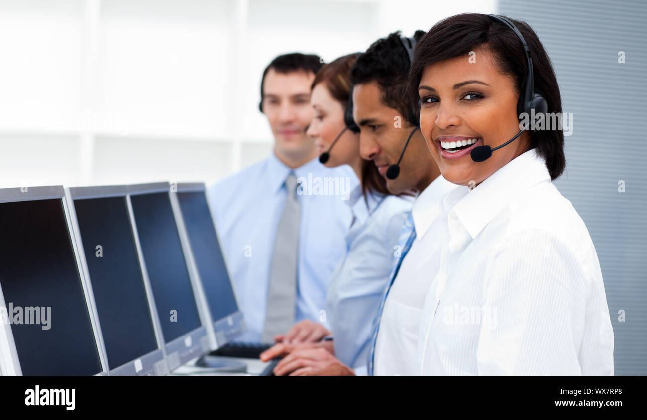 Happy co-workers with headsets on working in call center. Business ...