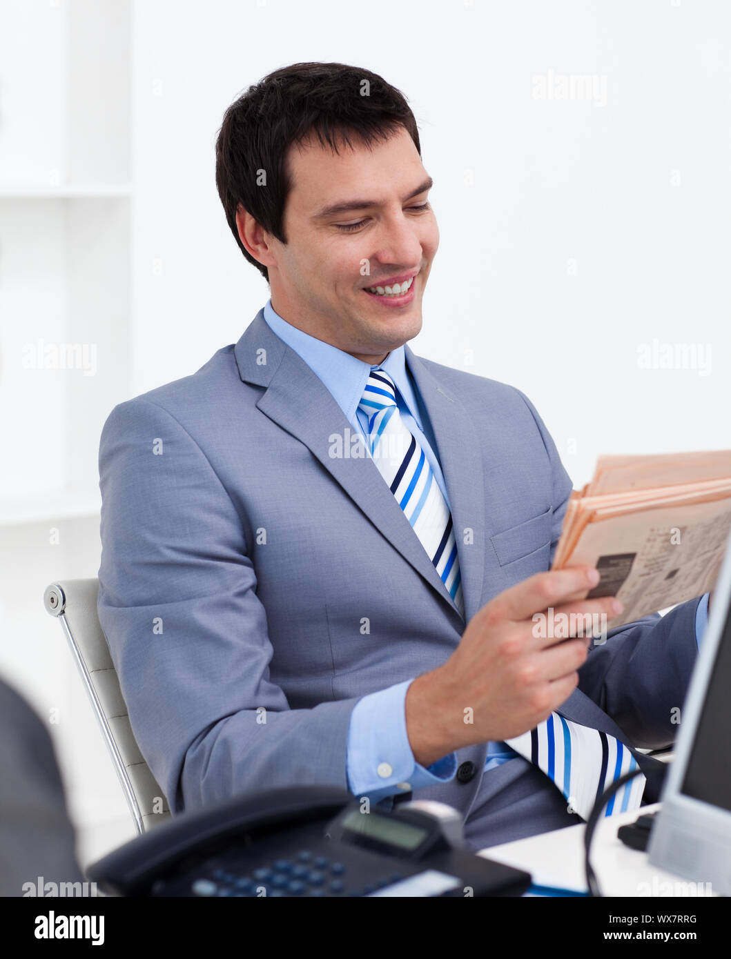 Attractive young businessman reading a newspaper in the office Stock ...