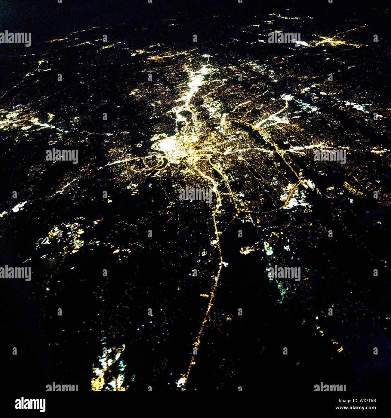 Flying at night over cities below Stock Photo