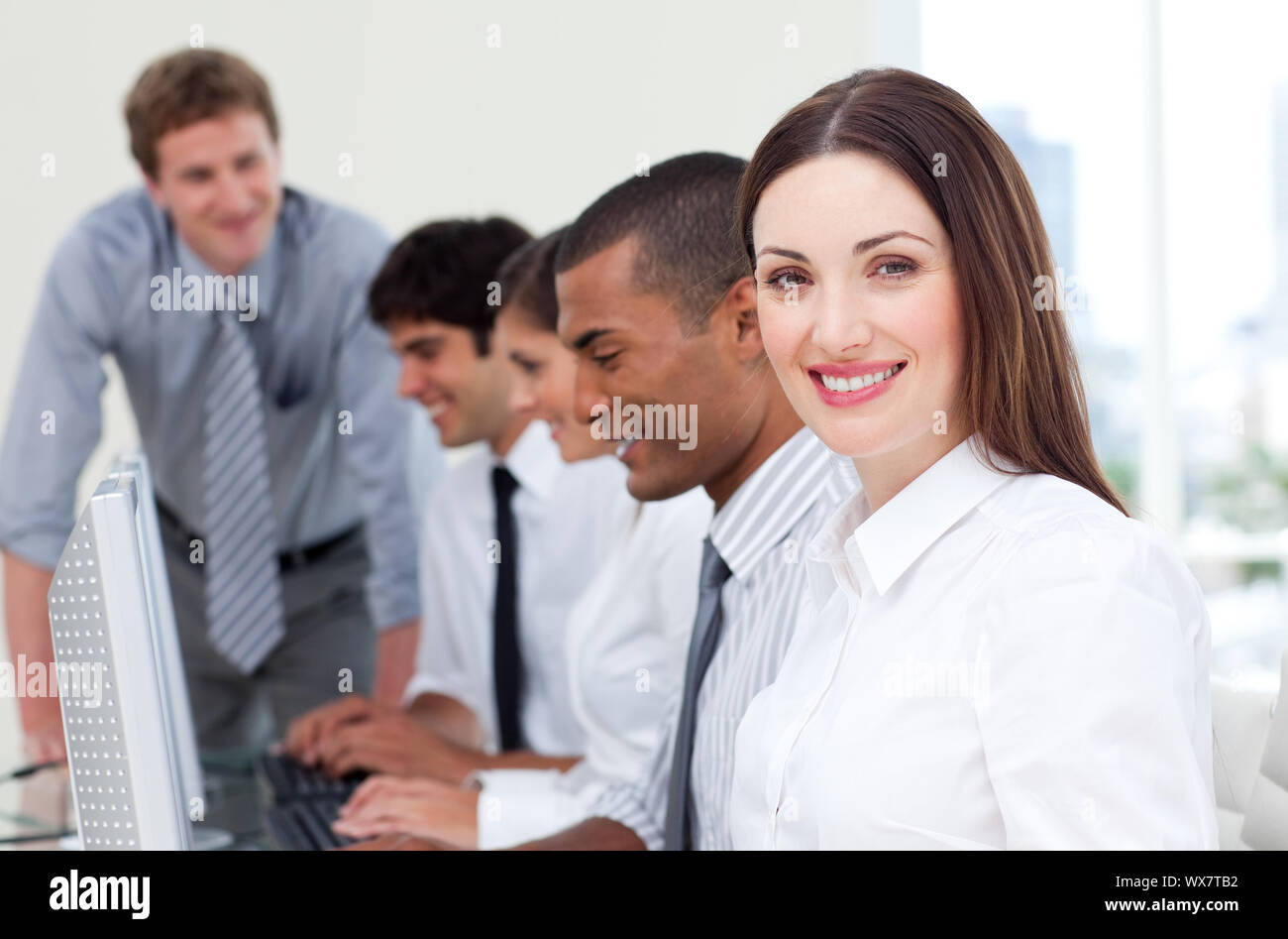 Brunette businesswoman and her team working at computers Stock Photo