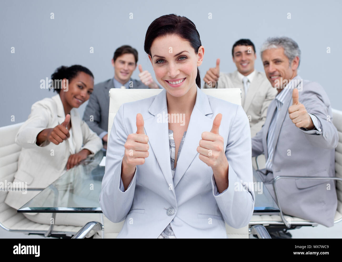 Happy business team with thumbs up in the office Stock Photo - Alamy