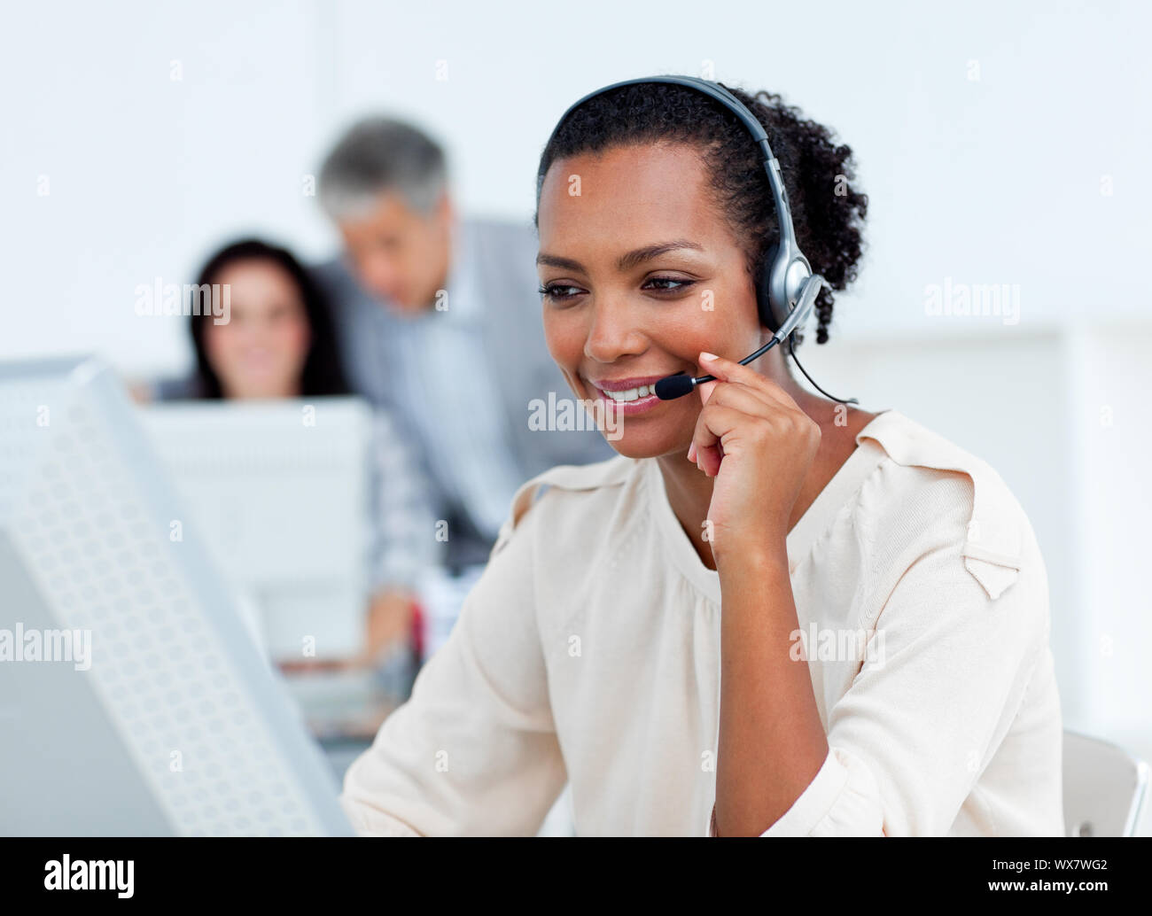 Confident businesswoman talking on headset at work Stock Photo