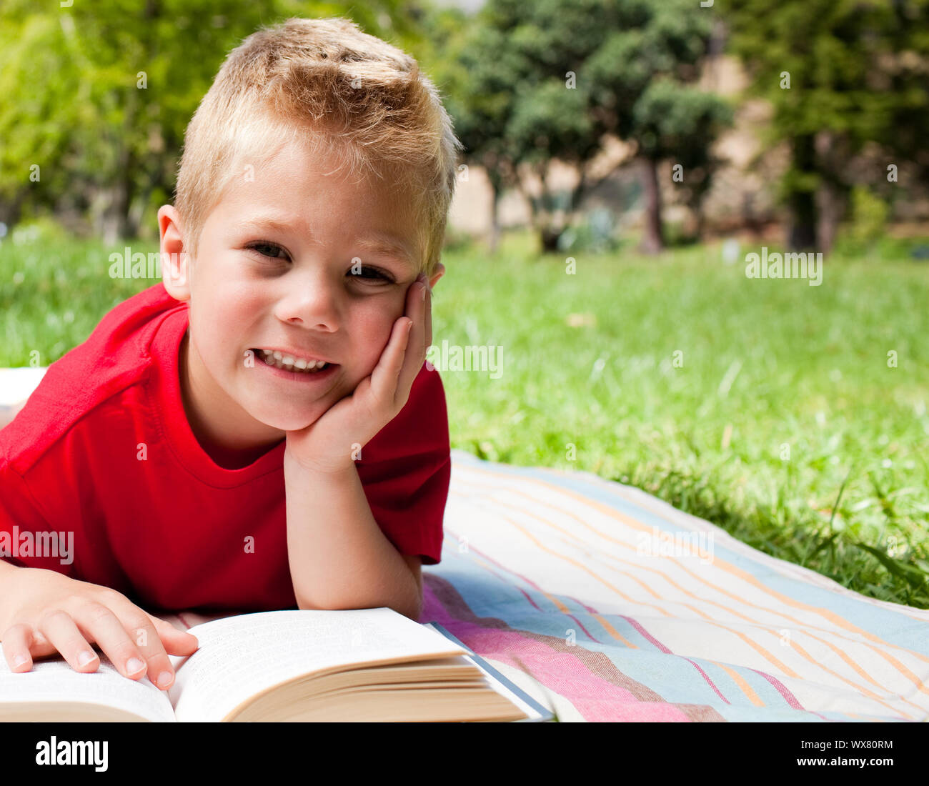 Mother and boy reading book. The little boy smiles and looks at the Camera.