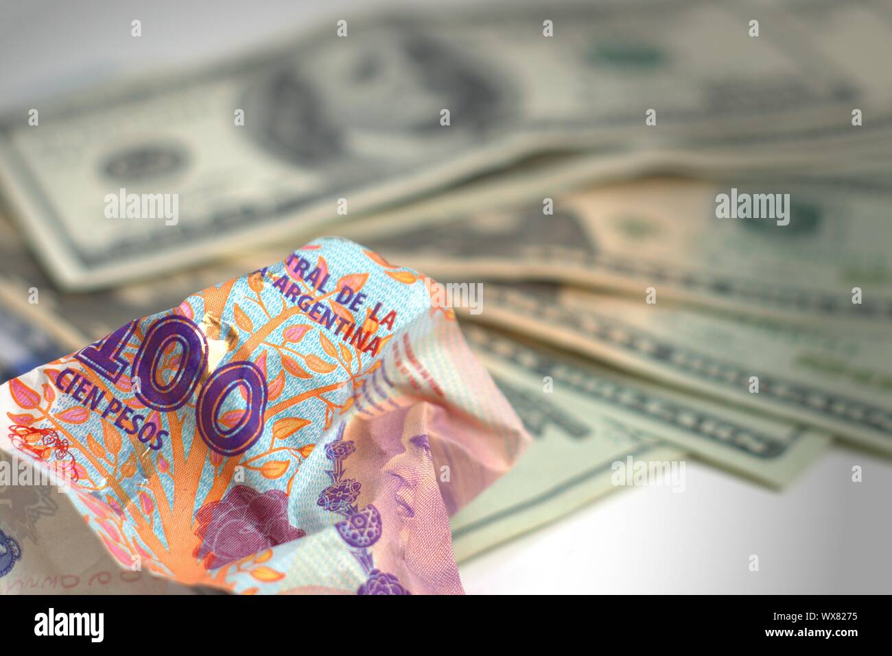 Argentina economic crisis and currency devaluation. Crumpled argentinian  banknote and intact US banknotes. Concept metaphor Stock Photo - Alamy