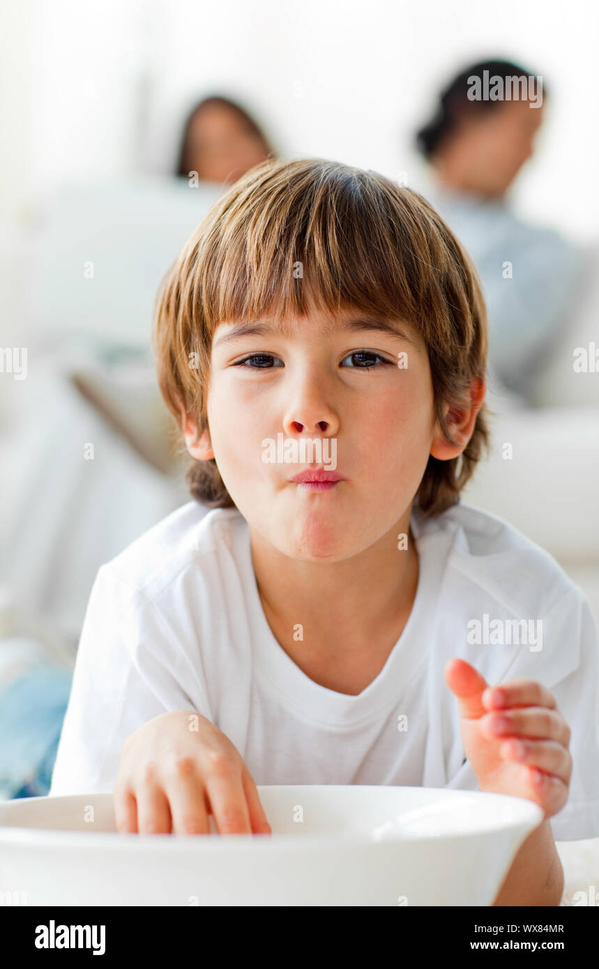 Adorable little boy eating chips lying on the floor in the living-room Stock Photo