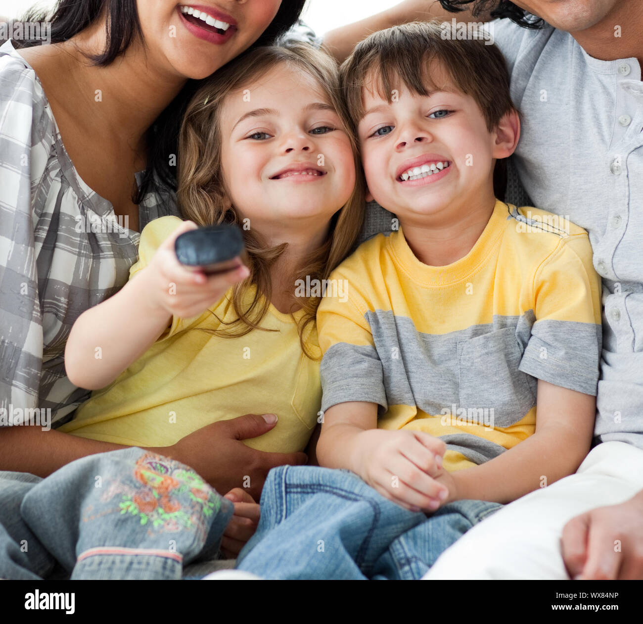 Cute children watching TV with their parents in the living-room Stock Photo